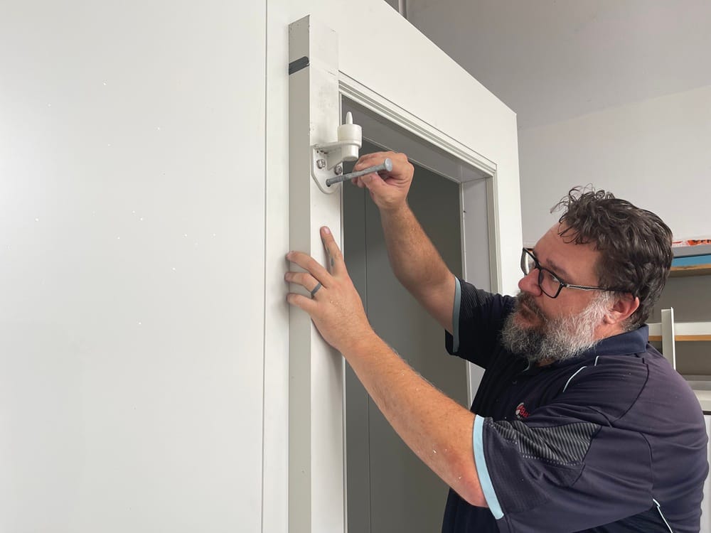man placing hinge into a Build your own cool room kit by Climascope